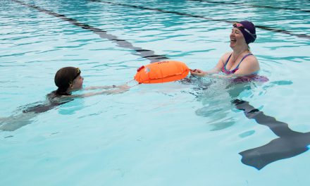 Met een zwemboei zwemmen In zee